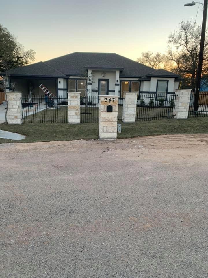Finished lawn behind the iron fence and stone pillars at house 347