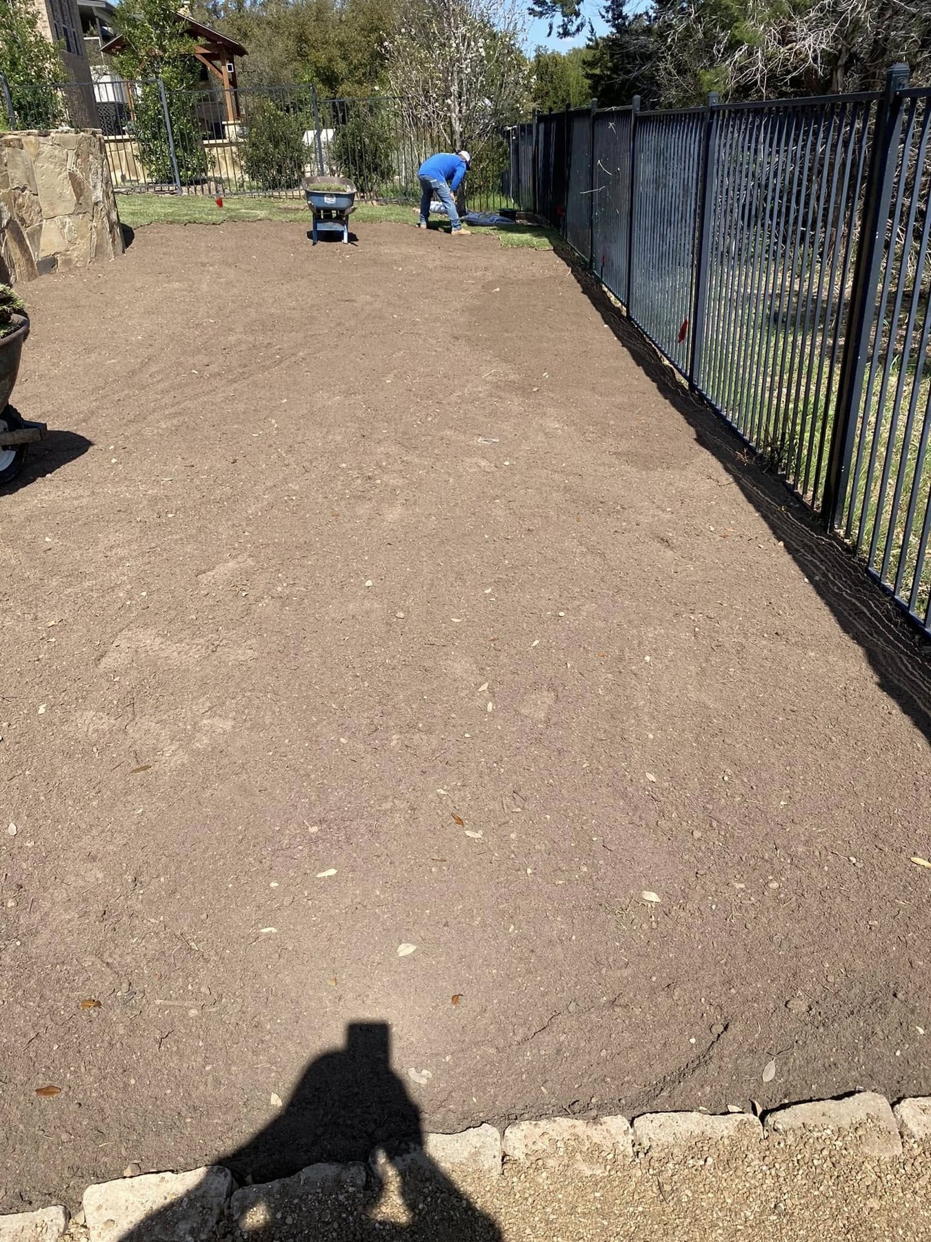 Prepared bare soil in the same side yard before sod installation